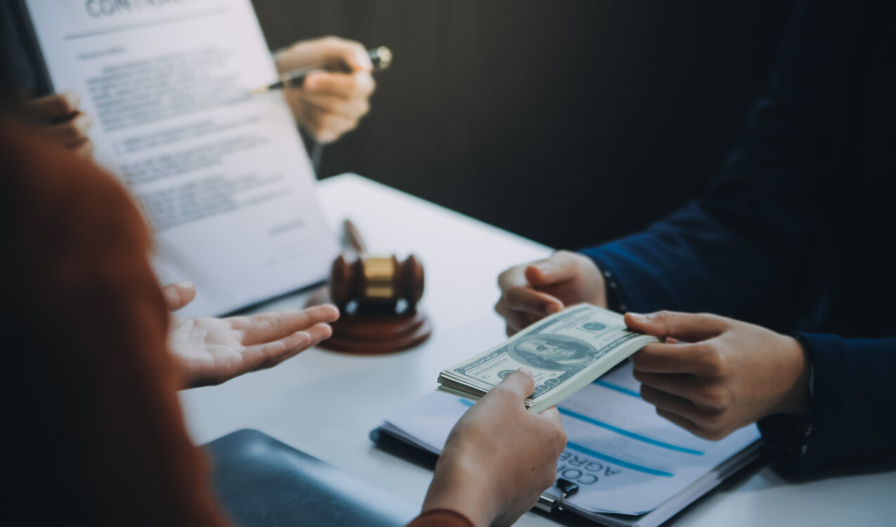 Customer receiving cash from a licensed moneylender during a loan agreement, representing legal lending services and common myths about licensed moneylenders.
