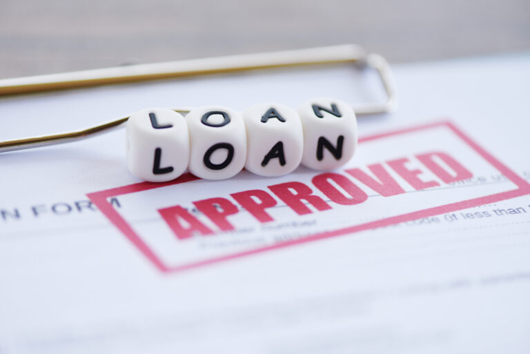 Loan approval document with "Approved" stamp and loan text blocks, representing fast loan approval and financing services from Khalon & Gill.